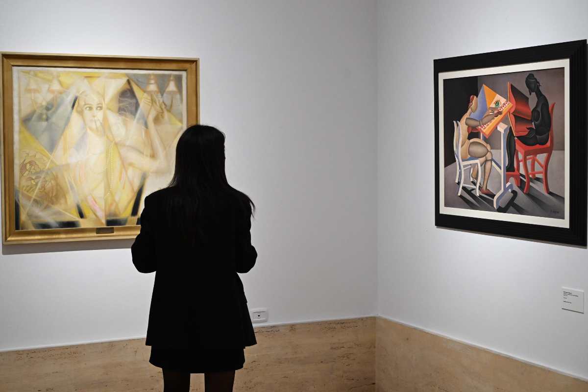 Una ragazza guarda due quadri in una galleria d'arte