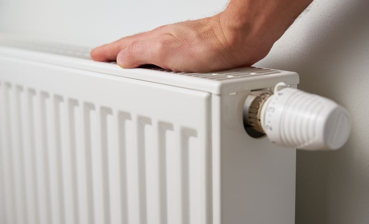 donna che tocca termosifone