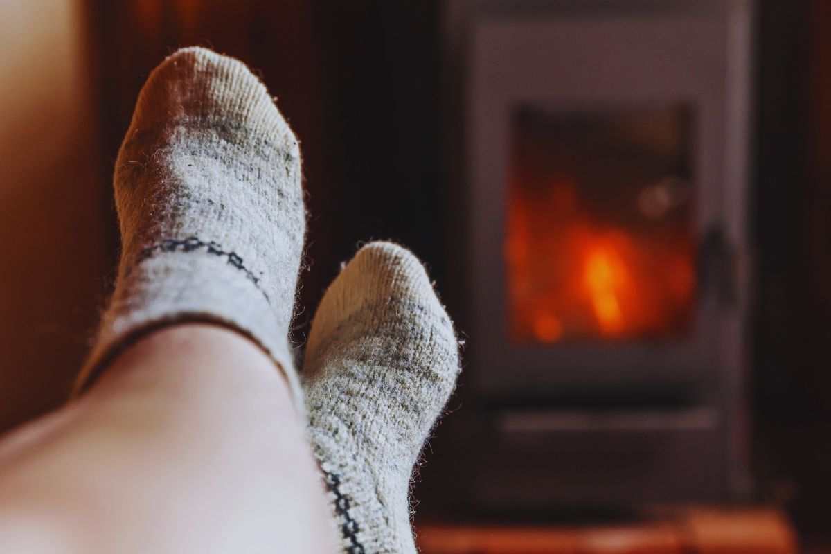 Piedi e gambe di una donna davanti ad una stufa