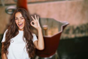 moka con caffè e donna che fa ok con le mani