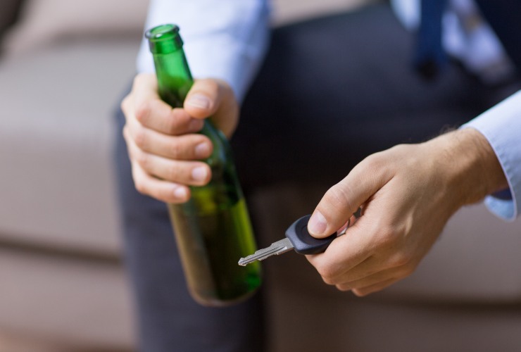 uomo con chiavi e bottiglia di birra in mano