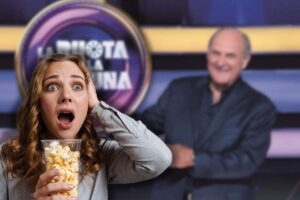 gerry scotti e la ruota della fortuna con donna sconvolta con pop corn in mano