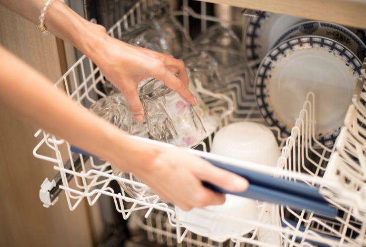 donna mette bicchieri in lavastoviglie