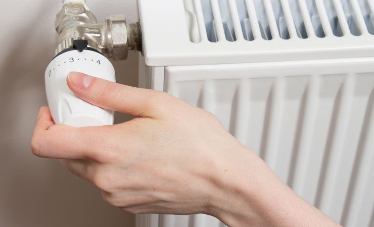 donna usa manopola dei termosifoni
